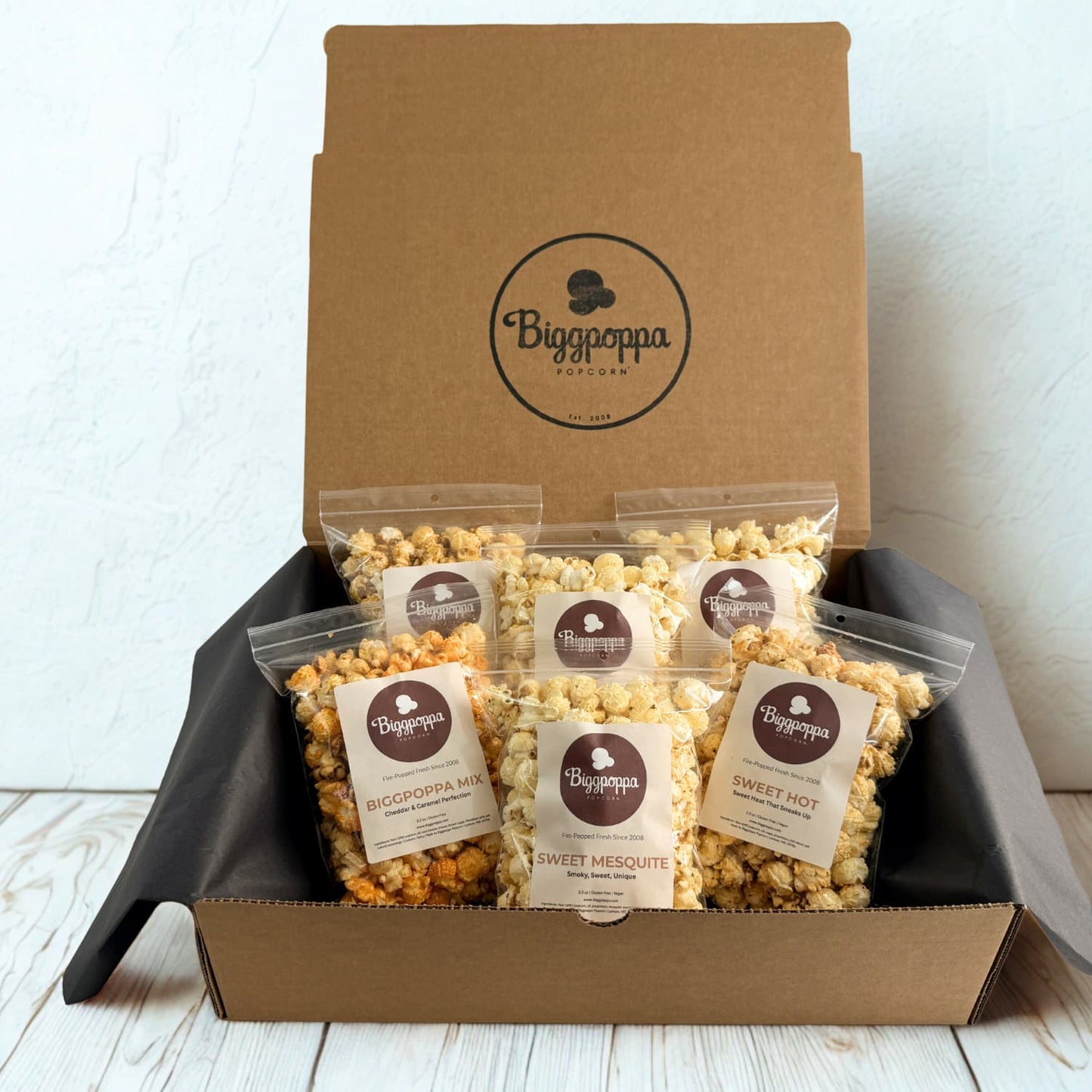 Box of Biggpoppa Popcorn with various flavors on a white background