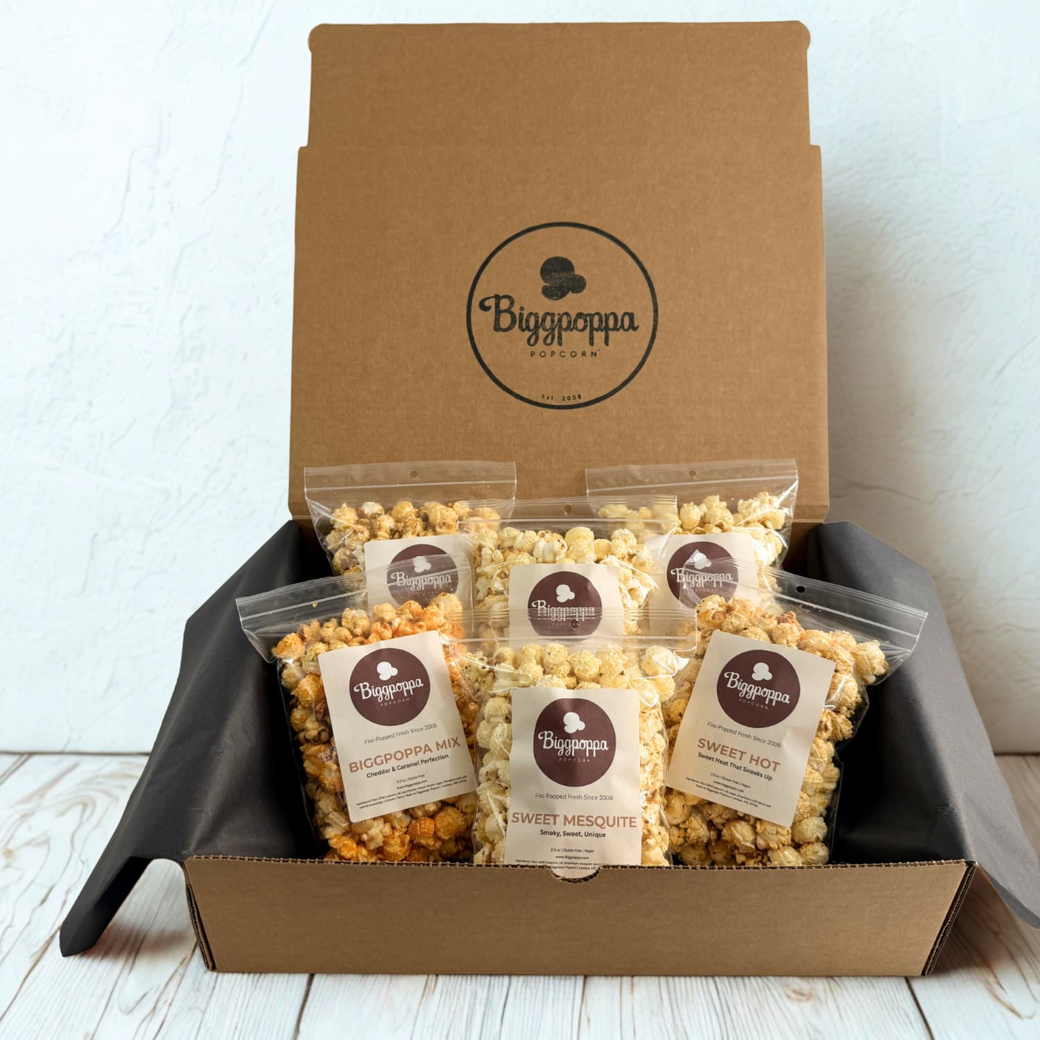 Box of Biggpoppa Popcorn with various flavors on a white background
