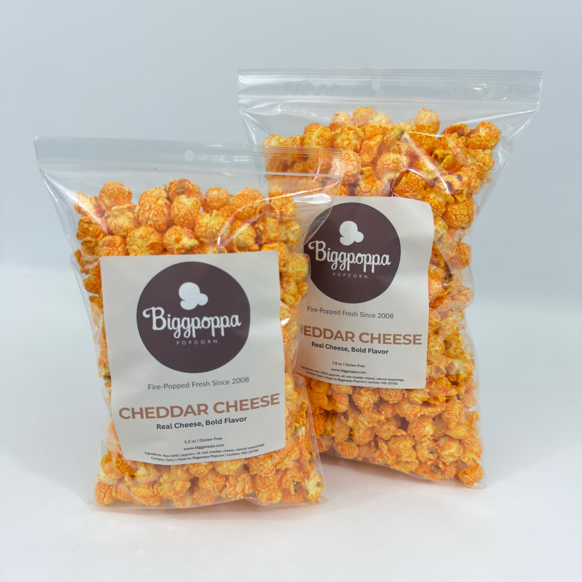 Two bags of Cheddar Cheese popcorn with Biggpoppa labels on a white background