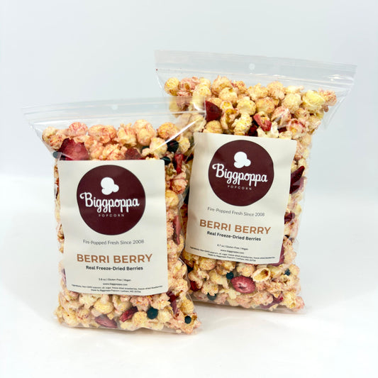Two bags of Biggopoppa Berri Berry popcorn on a white background